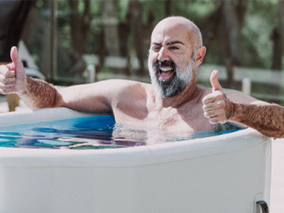 testimonial melchior sitzt lachend im horizon eisbad und zeigt beide daumen nach oben